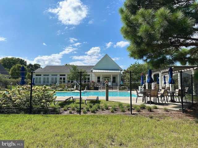 community pool with fence and a yard