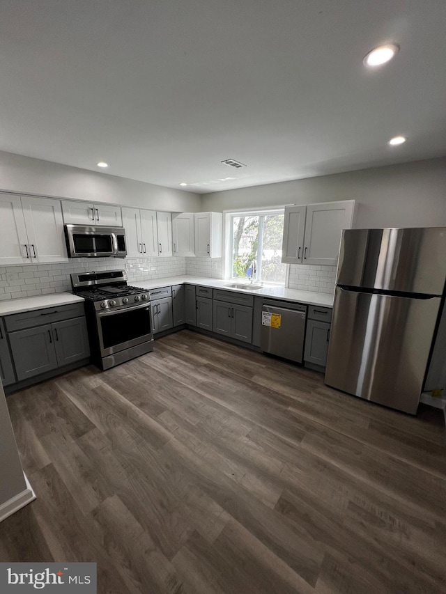 kitchen with sink, stainless steel appliances, dark hardwood / wood-style flooring, and gray cabinets