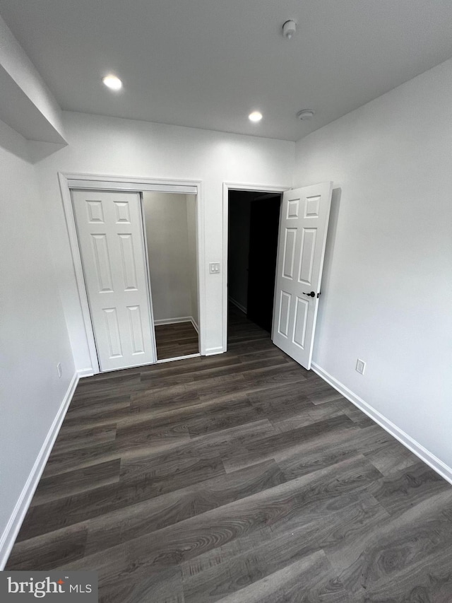 unfurnished bedroom featuring a closet and hardwood / wood-style flooring