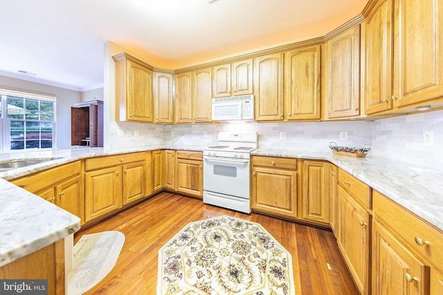 kitchen with light wood-type flooring, white appliances, crown molding, and tasteful backsplash