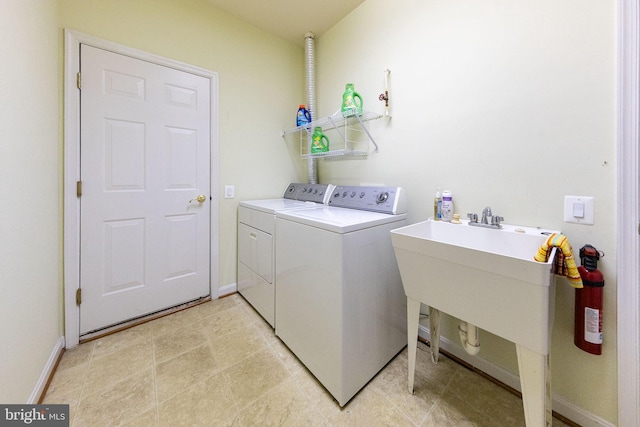 laundry room with washing machine and clothes dryer and light tile patterned floors