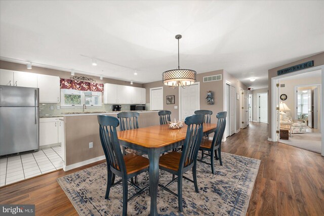 dining room with an inviting chandelier and light wood-type flooring