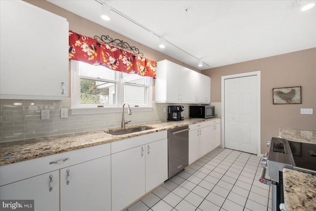 kitchen featuring light tile patterned flooring, sink, backsplash, white cabinetry, and stainless steel appliances