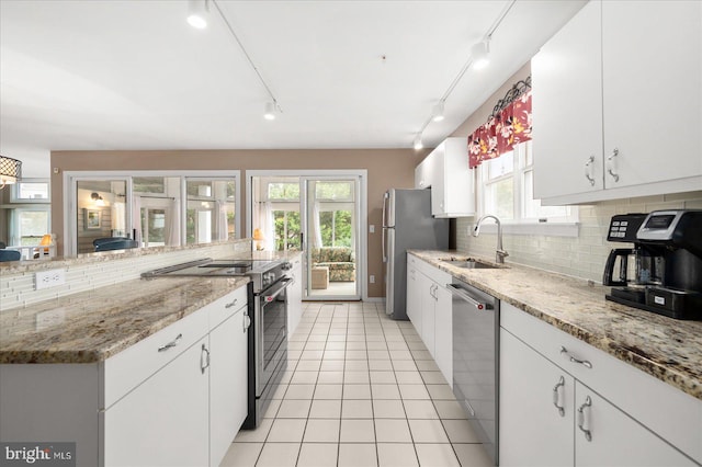 kitchen with a wealth of natural light, stainless steel appliances, and white cabinetry