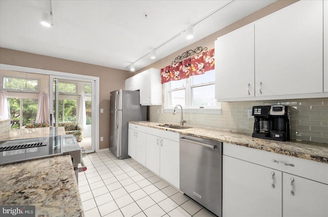 kitchen featuring white cabinets, backsplash, appliances with stainless steel finishes, and sink