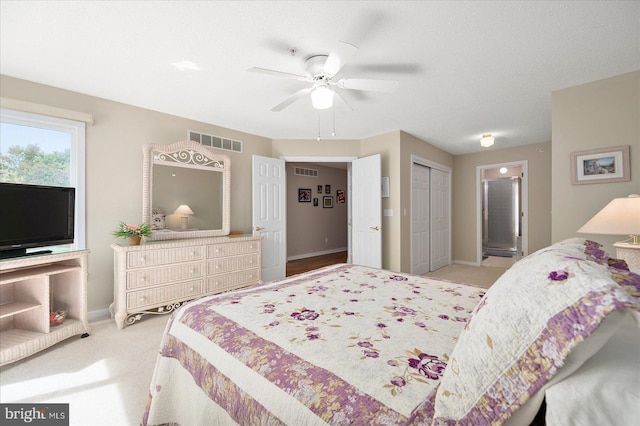 carpeted bedroom with ceiling fan, a textured ceiling, and a closet