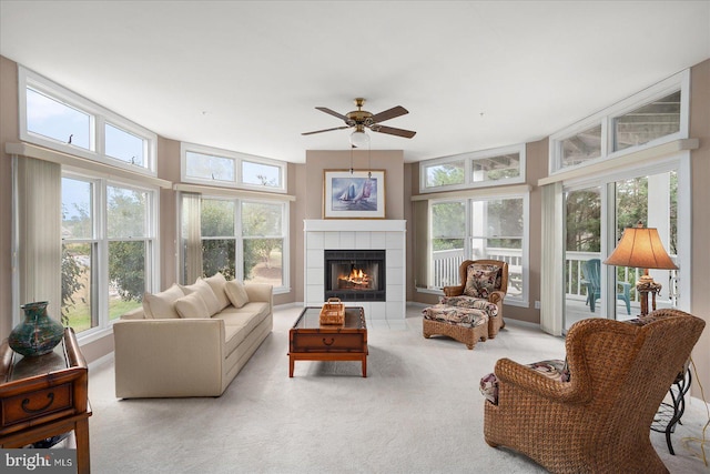 carpeted living room featuring ceiling fan and a fireplace