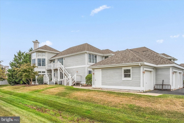 back of property featuring a garage and a lawn