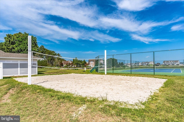 view of home's community featuring tennis court, a yard, and volleyball court