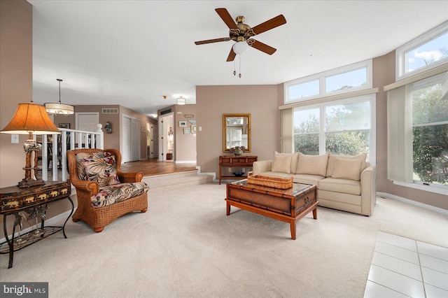 living room featuring light carpet, lofted ceiling, ceiling fan, and plenty of natural light