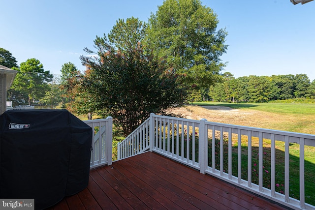 wooden deck featuring a lawn and area for grilling