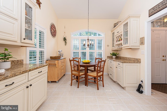 dining space featuring baseboards, a chandelier, and light tile patterned flooring