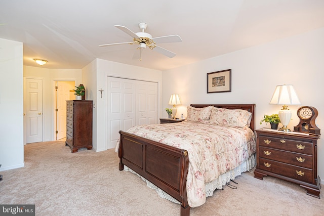 bedroom with light carpet, a ceiling fan, and a closet