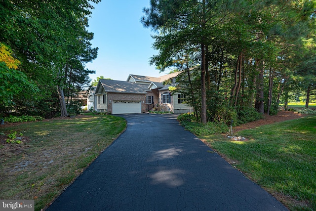 view of front of property with a garage, aphalt driveway, and a front lawn