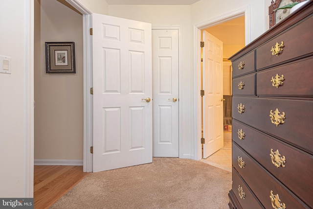 corridor with light carpet and baseboards