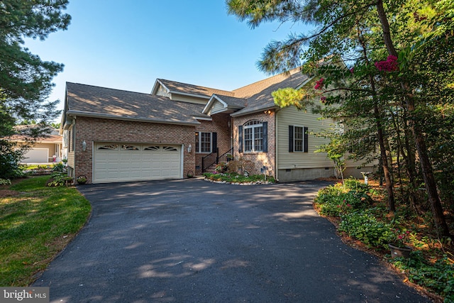 view of front of home featuring driveway, brick siding, crawl space, and an attached garage