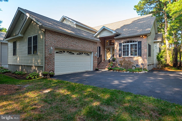 view of front of property featuring aphalt driveway, crawl space, brick siding, and an attached garage