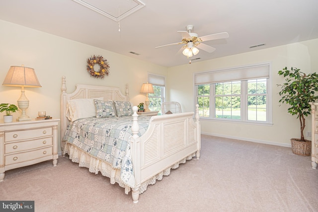 bedroom with light carpet, visible vents, attic access, and baseboards