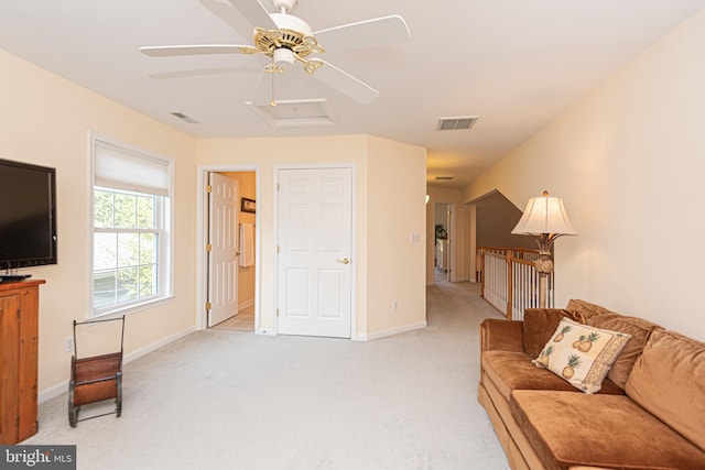 living room with attic access, light carpet, visible vents, and baseboards