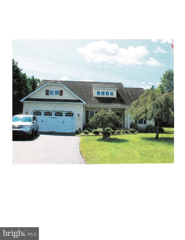 view of front of property featuring a garage and a front lawn