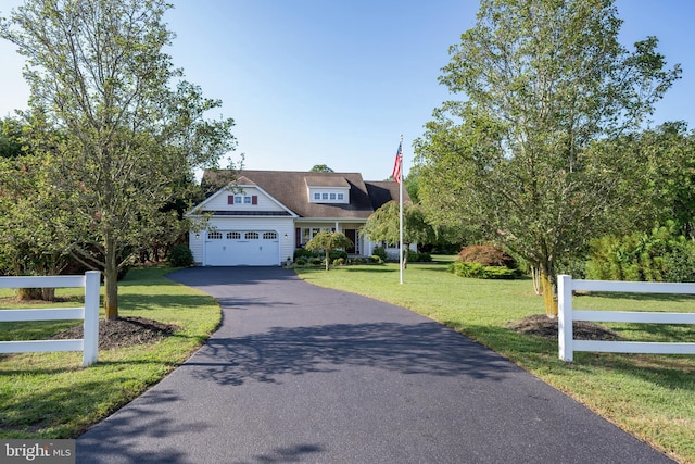 view of front of house with aphalt driveway, a front yard, fence, and an attached garage