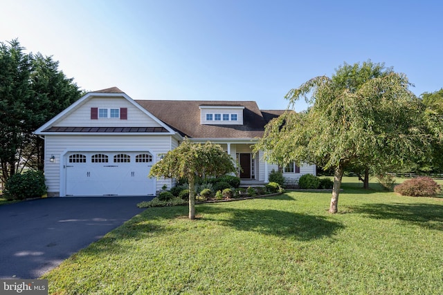 view of front facade featuring metal roof, a garage, driveway, a front lawn, and a standing seam roof