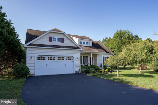 view of front of house with a garage, driveway, a standing seam roof, and a front yard