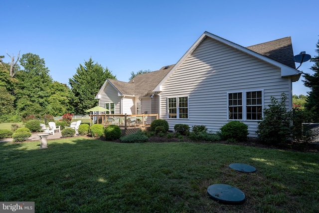 rear view of property featuring a wooden deck and a yard