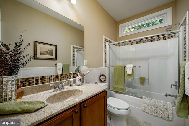 bathroom featuring decorative backsplash, shower / bath combination with glass door, vanity, and toilet