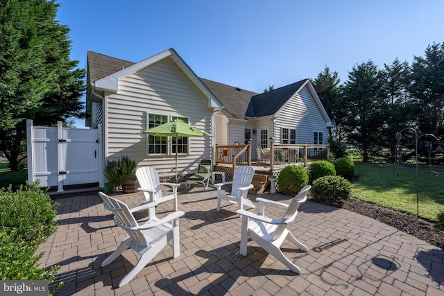 rear view of house with a patio area, a yard, and a wooden deck