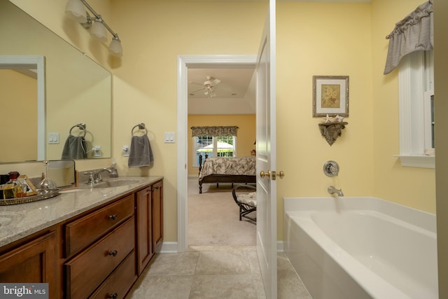 bathroom featuring ceiling fan, tile patterned flooring, a bathing tub, and vanity