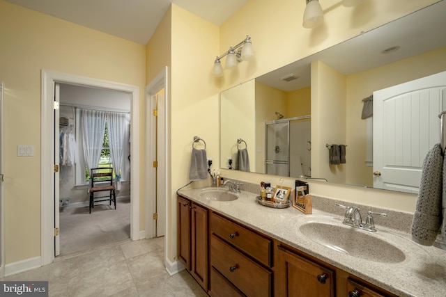 bathroom with tile patterned flooring, walk in shower, and vanity