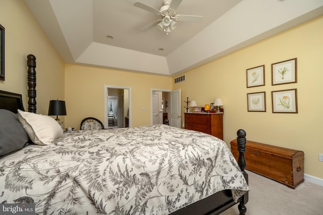 carpeted bedroom featuring ceiling fan and a tray ceiling