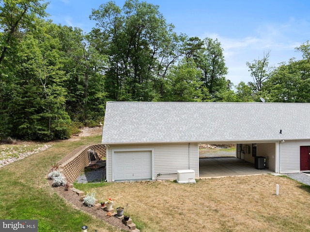 garage with a carport and a yard