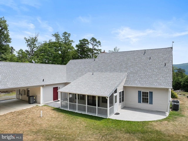 back of house featuring a sunroom, central AC, and a lawn