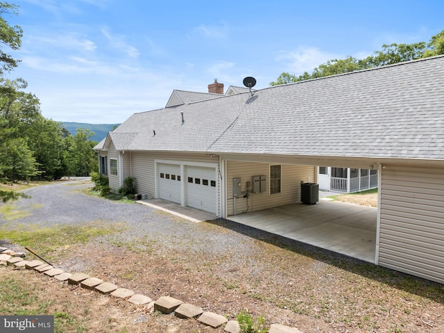 view of side of property with central air condition unit and a garage