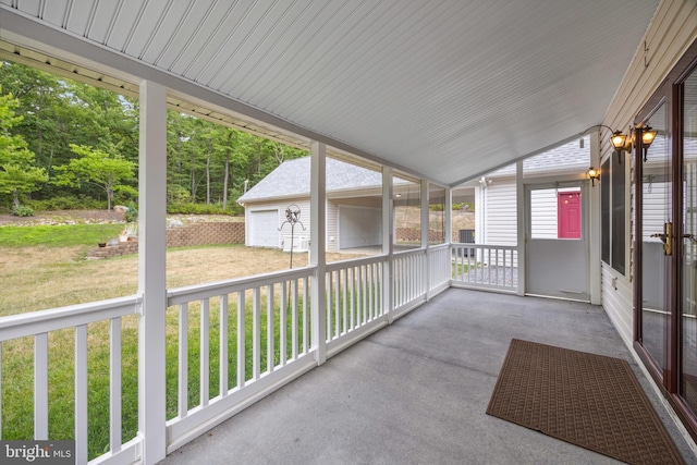 unfurnished sunroom featuring vaulted ceiling and a healthy amount of sunlight