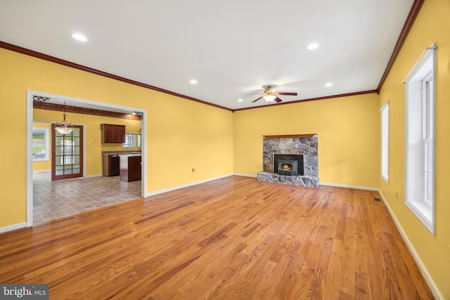 unfurnished living room featuring ceiling fan, light tile patterned flooring, and a stone fireplace