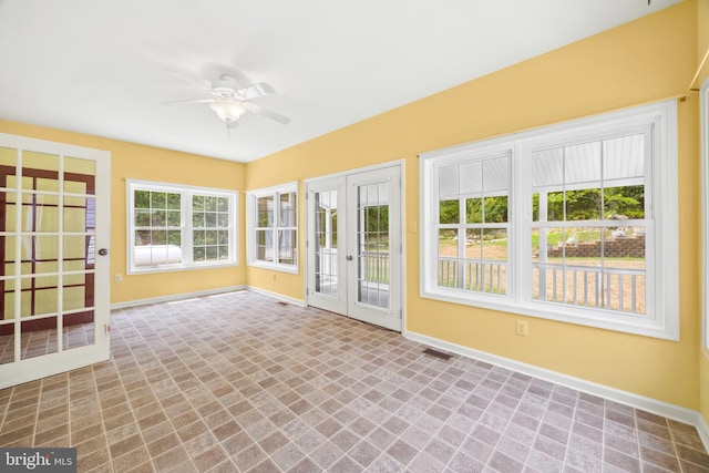 unfurnished sunroom with ceiling fan and french doors