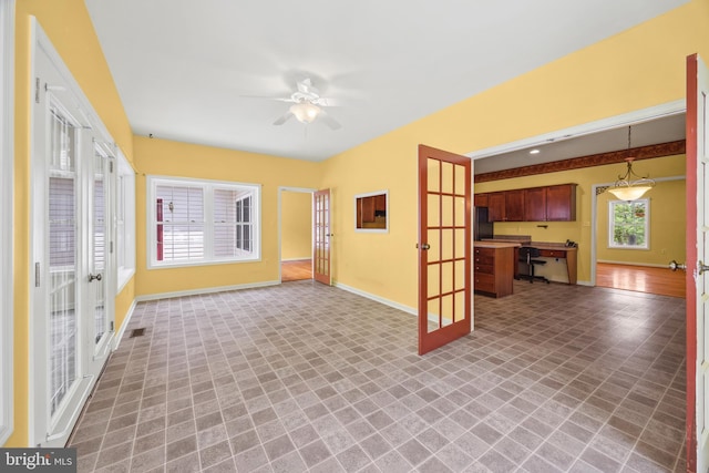 unfurnished living room featuring tile patterned floors, french doors, and ceiling fan