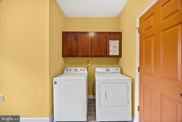 laundry area with tile patterned flooring, cabinets, and washer and clothes dryer