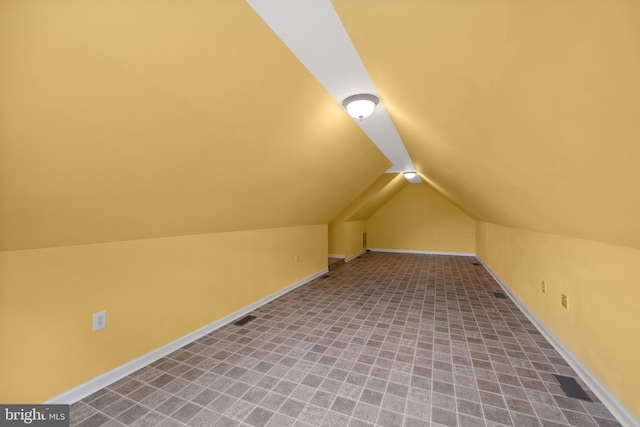 bonus room with light colored carpet and lofted ceiling