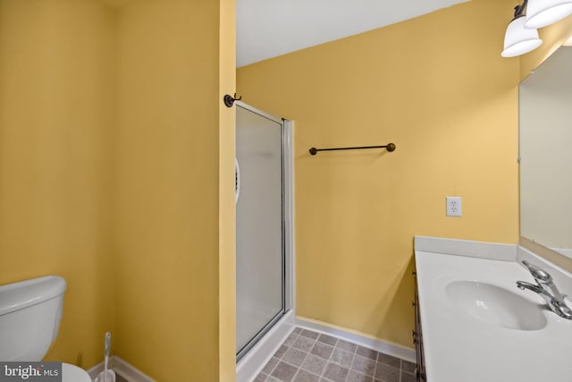 bathroom featuring tile patterned flooring, toilet, vanity, and walk in shower