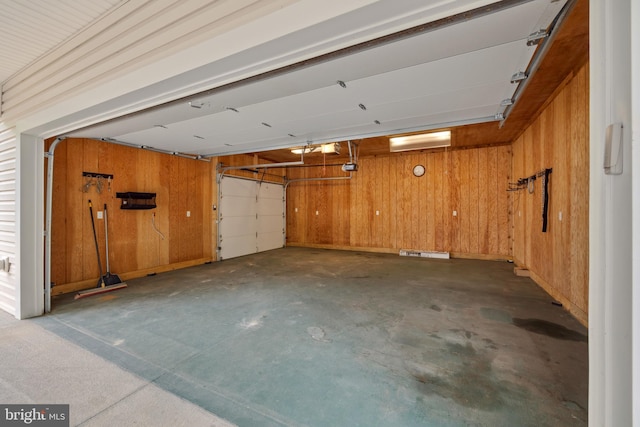 garage with a garage door opener and wooden walls