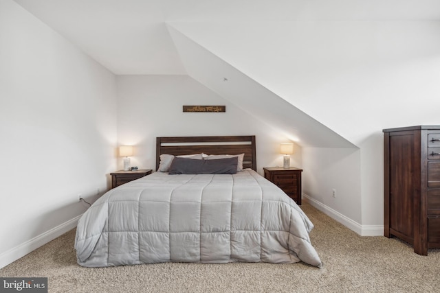 carpeted bedroom with lofted ceiling