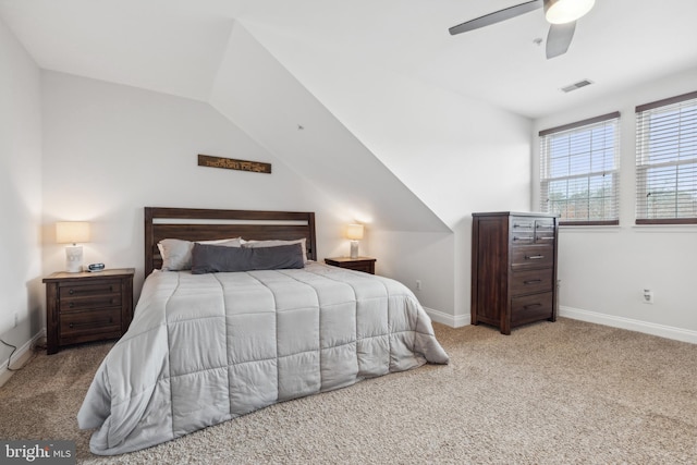 bedroom with ceiling fan, light colored carpet, and vaulted ceiling