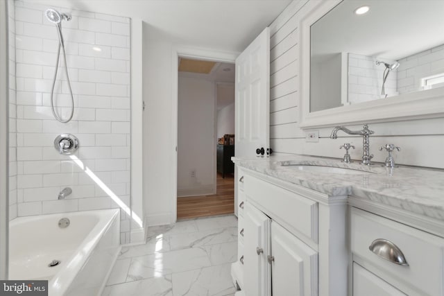 bathroom with vanity, tiled shower / bath combo, and wood-type flooring