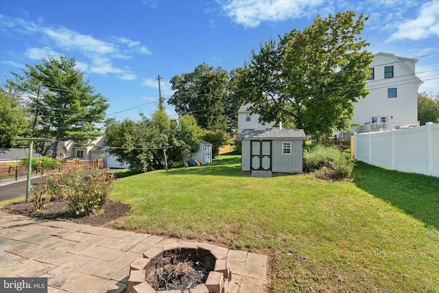 view of yard featuring a storage unit and a fire pit