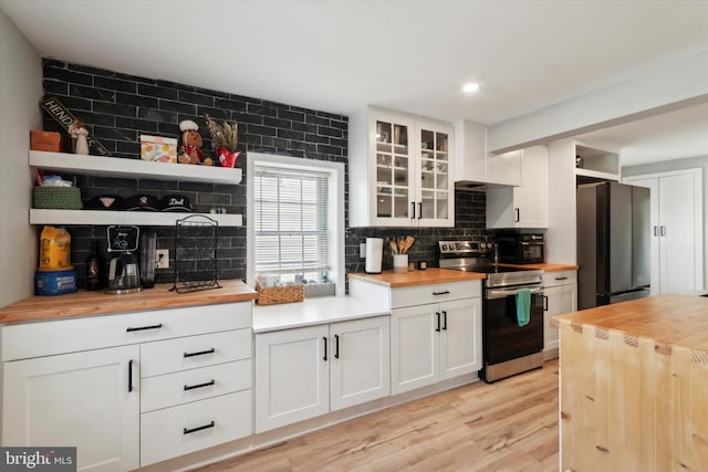 kitchen with wooden counters, fridge, stainless steel electric range oven, white cabinetry, and light hardwood / wood-style floors