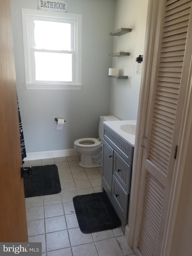 bathroom featuring vanity, tile patterned flooring, and toilet